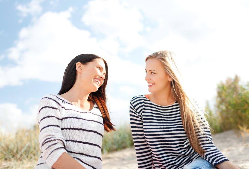 summer, holidays, vacation, happy people concept - smiling girlfriends having fun on the beach